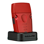 Red BaBylissPRO lo-pro compact shaver on black charging base on a white background 