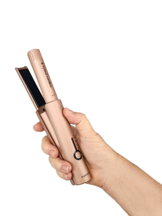Hand holding a rose gold hair straightener on a white background