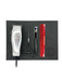 Set of hair cutting tools including a clipper, scissors, and comb on a black tray with a white background.