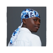 Person wearing a blue camouflage headscarf on a gray background