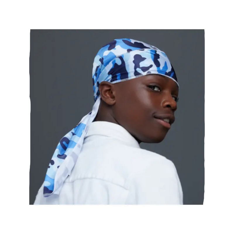 Person wearing a blue camouflage headscarf on a gray background