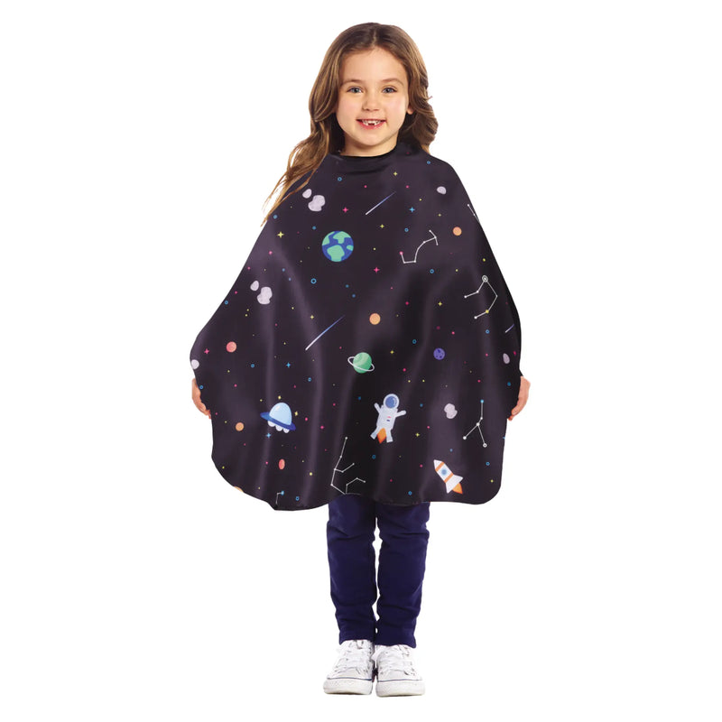 Child wearing a salon cutting cape with space-themed designs on a white background