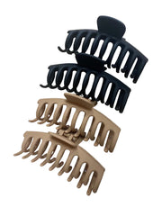 Two black and two brown matte finished rubberized claw clips on white background