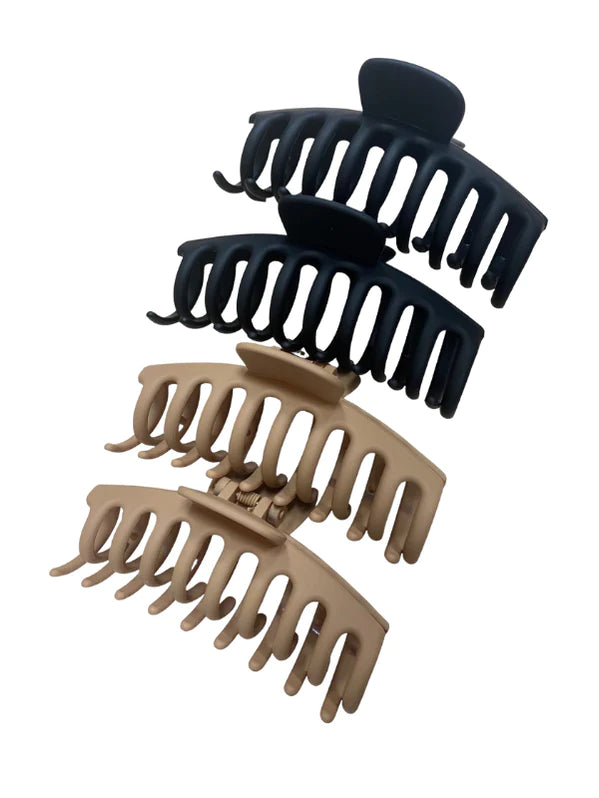 Two black and two brown matte finished rubberized claw clips on white background
