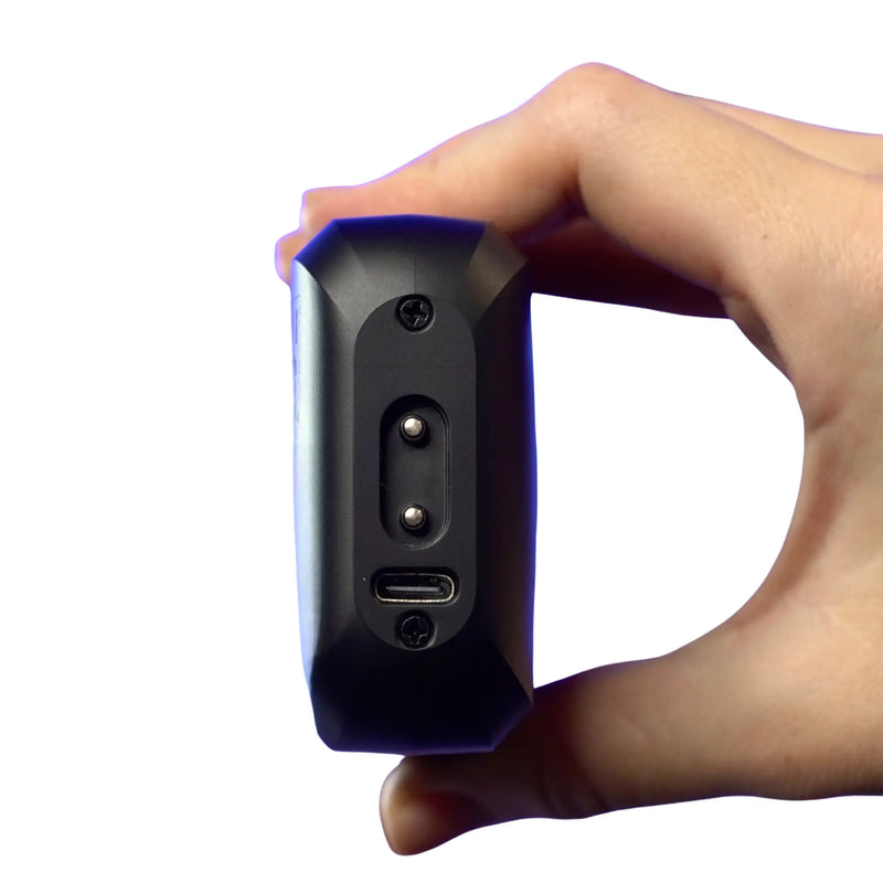 Hand holding a Supreme Trimmer double foil shaver, showing charging port with a white background