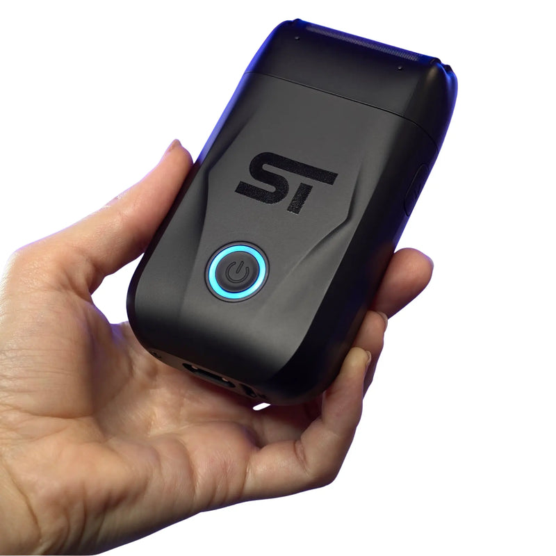 Hand holding a black Supreme Trimmer shaver with a blue power on light on a white background