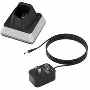 A black and silver charging dock with a coiled black power cable and a black wall charger 