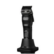 Black Philips Norelco hair clipper standing upright on its charging dock against a plain white background.