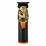 A cordless hair clipper with a black and orange body, featuring a transparent section showing a leafy camouflage pattern, on a solid white background.