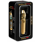 GoldFX+ BabylissPRO gold electric hair clipper shown inside its black retail packaging box, featuring a textured metallic gold finish.