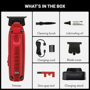 Box contents graphic for a Babyliss Pro red electric hair trimmer, showing the trimmer, cleaning brush, lubricating oil, charging cord, blade cover, zero-gap tool, and charging stand on a white background with a black header reading WHAT'S IN THE BOX.