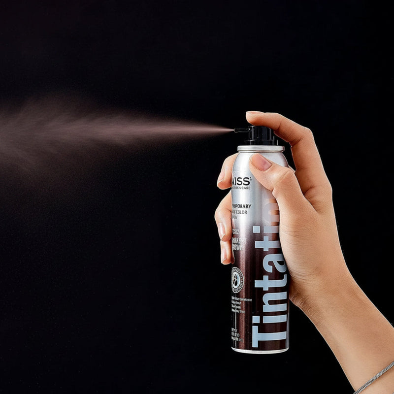 Hand holding a can of Miss Jessie's Tintation hair color spray against a black background