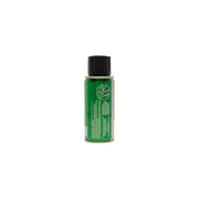 Green body spray bottle with black cap on a textured gray background
