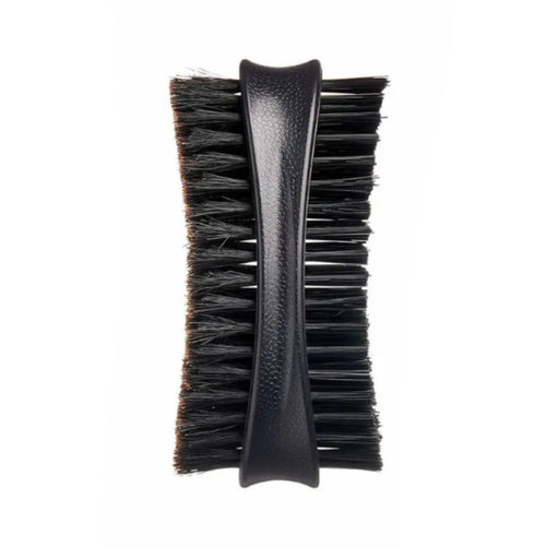 A close-up of a black grooming brush with a textured black handle and dense black bristles, shown against a plain white background.