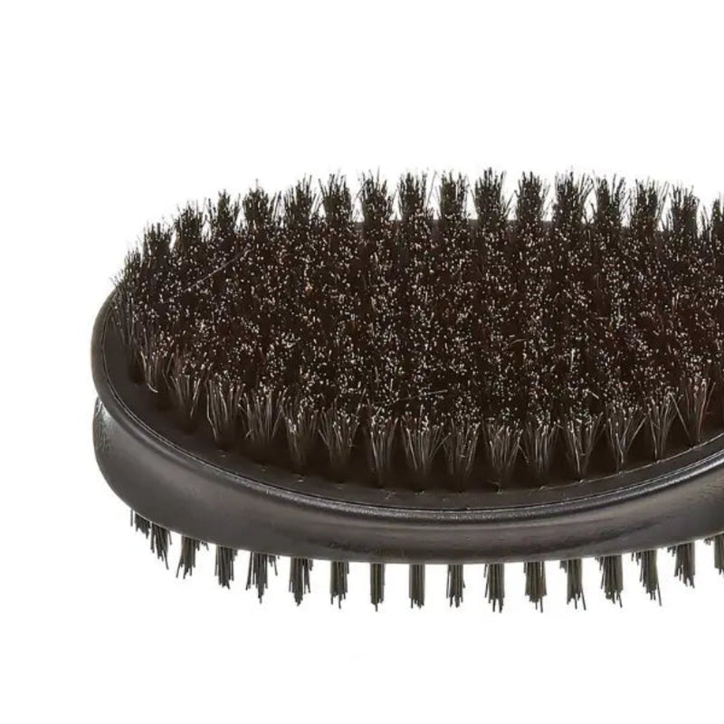 Close-up of a black oval hairbrush with dense dark bristles on a plain white background.